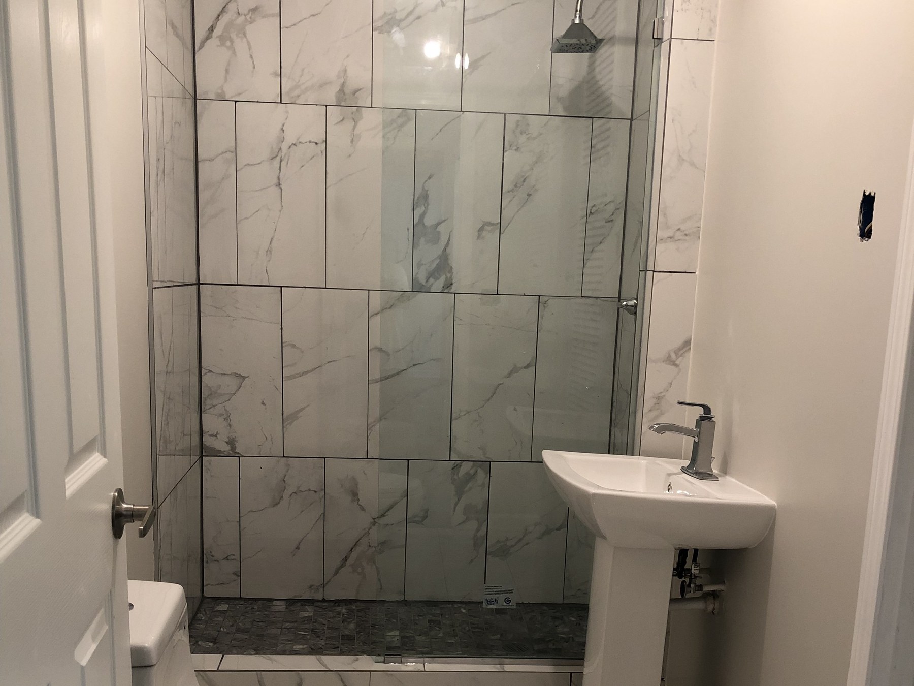 Finished Atlanta bathroom with marble tile shower and glass door